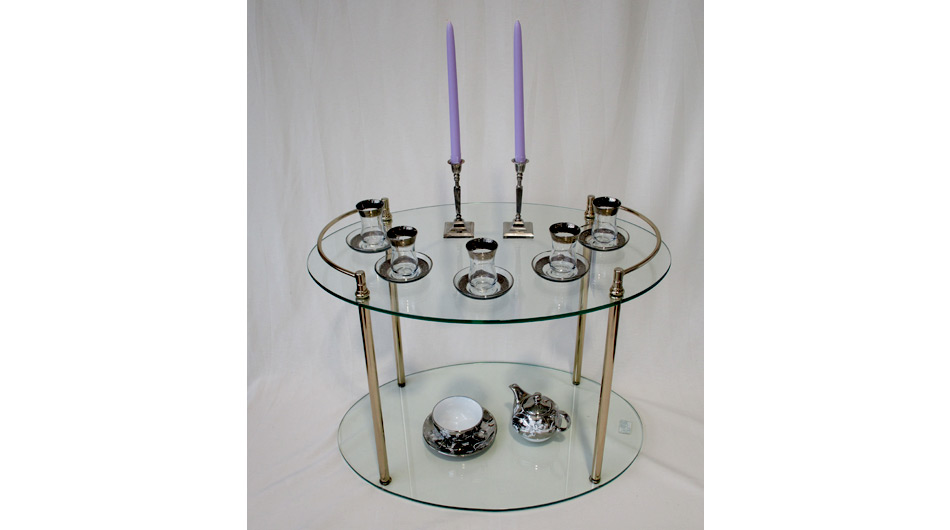 fairpunkt Siegburg: Ein Glastisch, zwei silberne Kerzenständer und mehrere Gläser mit silberfarbenen Untersetztern.