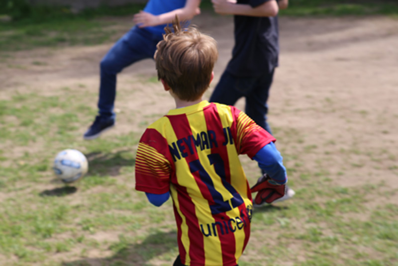Drei junge Bewohner in Stephansheide spielen Fußball.